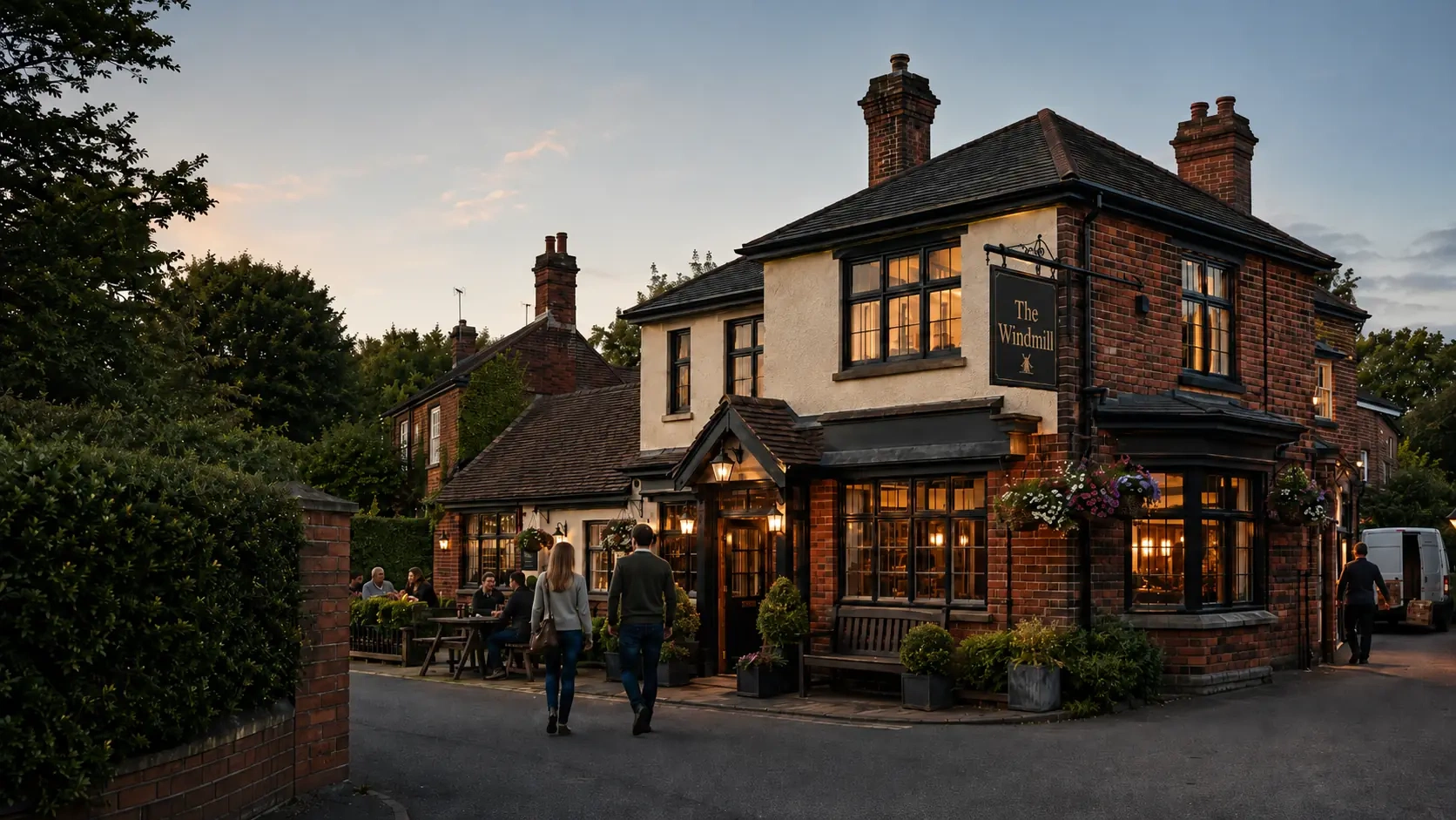 Traditional British pub exterior at dusk with The Windmill sign